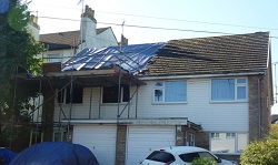 A roof covered with a tarpaulin during a roof repair Firm sentenced for asbestos failures