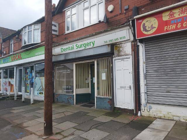 Exterior view of a high-street dental surgery and neighbouring retail units, used to illustrate commercial asbestos surveying and environmental compliance services for small businesses.