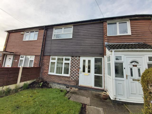 A front-facing view of a typical UK terraced house featuring a mix of brickwork and horizontal timber effect cladding, illustrating a common site for domestic asbestos surveys.